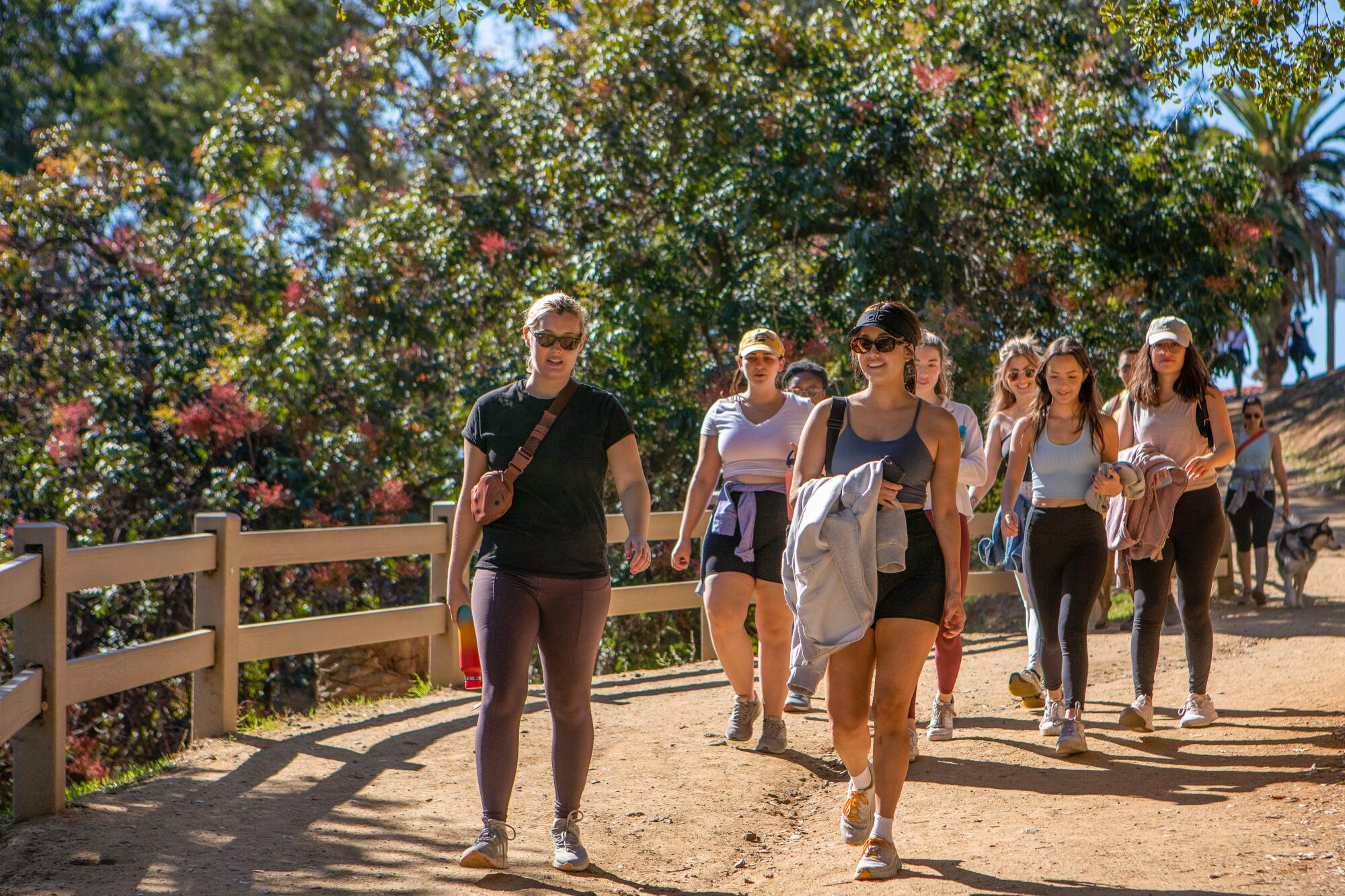 Small group of walkers gathered at a park entrance before starting a trail